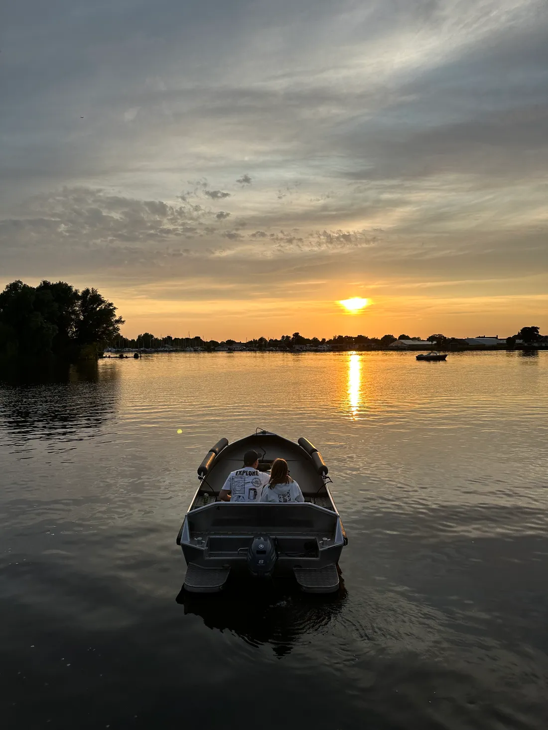 Twee klanten genieten van een tocht met een huurboot bij zonsondergang